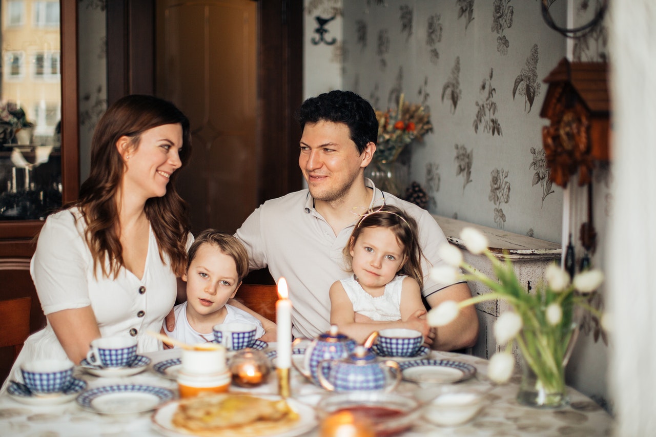 Familie sidder sammen og spiser morgenmad om sommeren